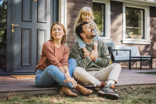 Happy family sitted on a porch enjoying their outdoor space.